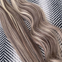 Balayage Mix Shade Human Hair Extensions on a textured background.