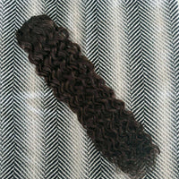 Curly hair extension on a textured gray and white background