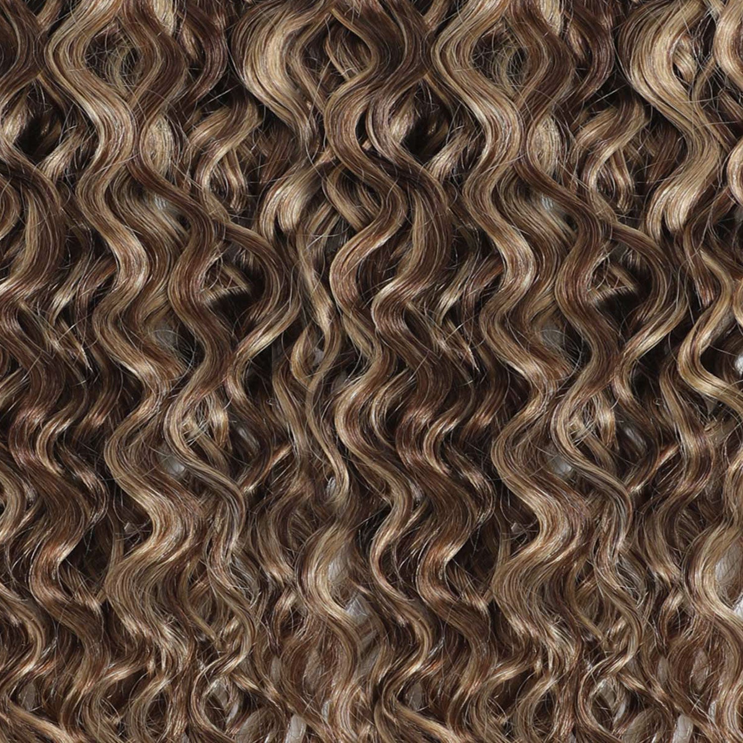 Close-up of wavy hair extensions with a brown and blonde color.