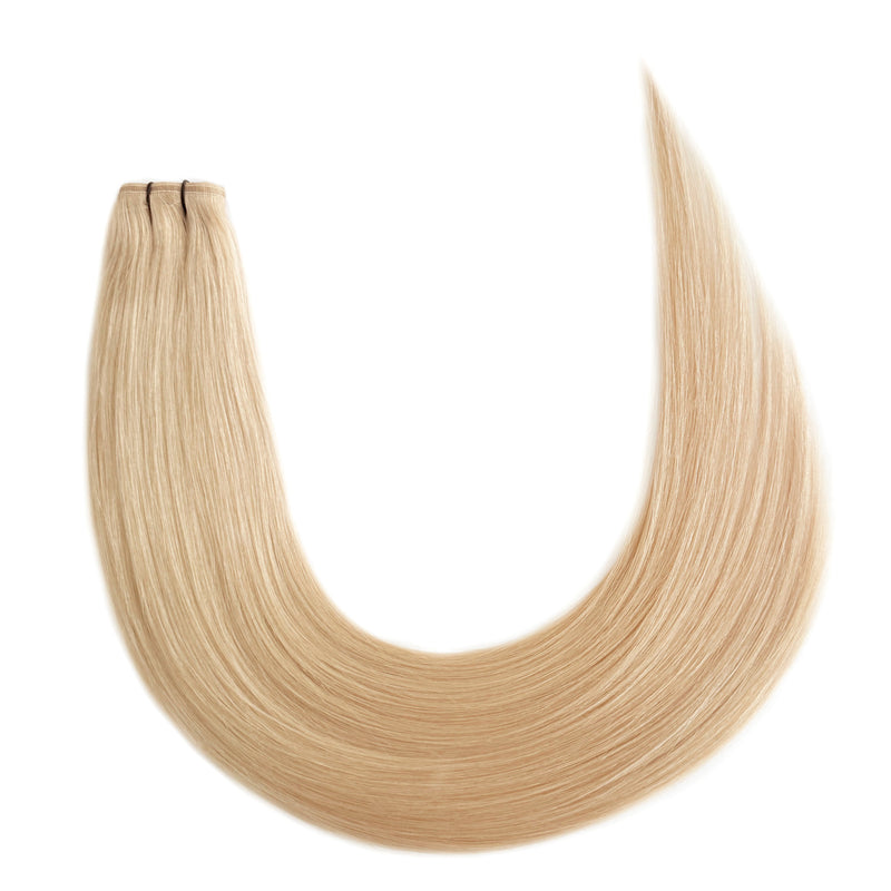 A set of champagne blonde flat weft hair extensions laid out in a U-shape on a white background.