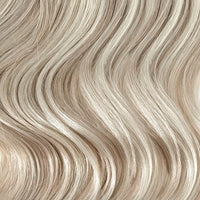 Close-up of wavy hair in a light ash blonde shade, showing the texture and color of the hair strands.