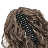 Brown hair extension with a black clip on a white background