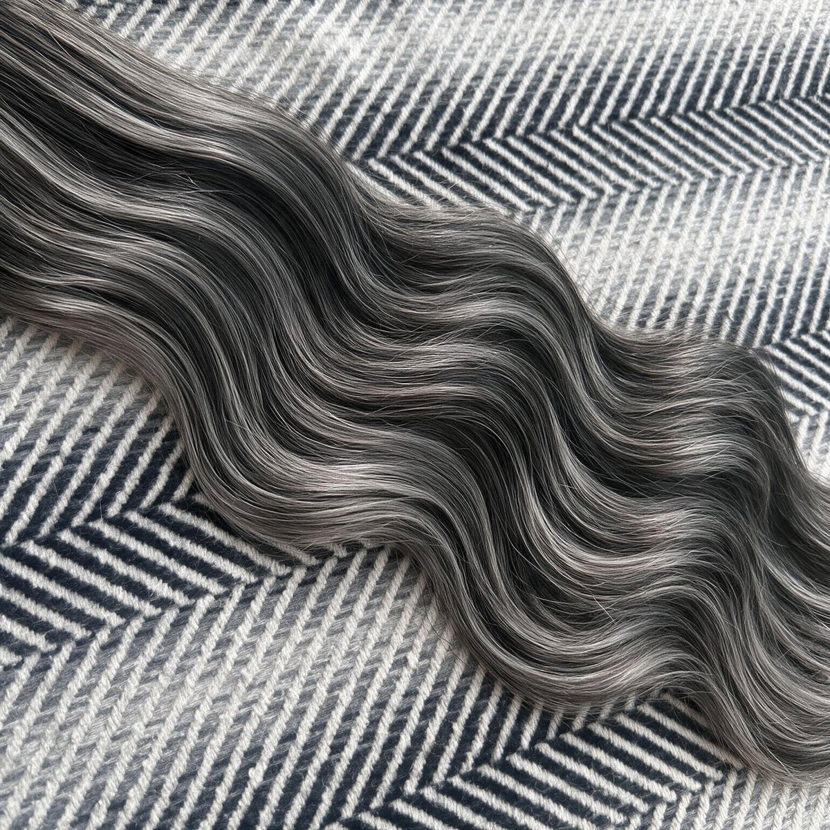 Close-up of gray and black herringbone pattern fabric
