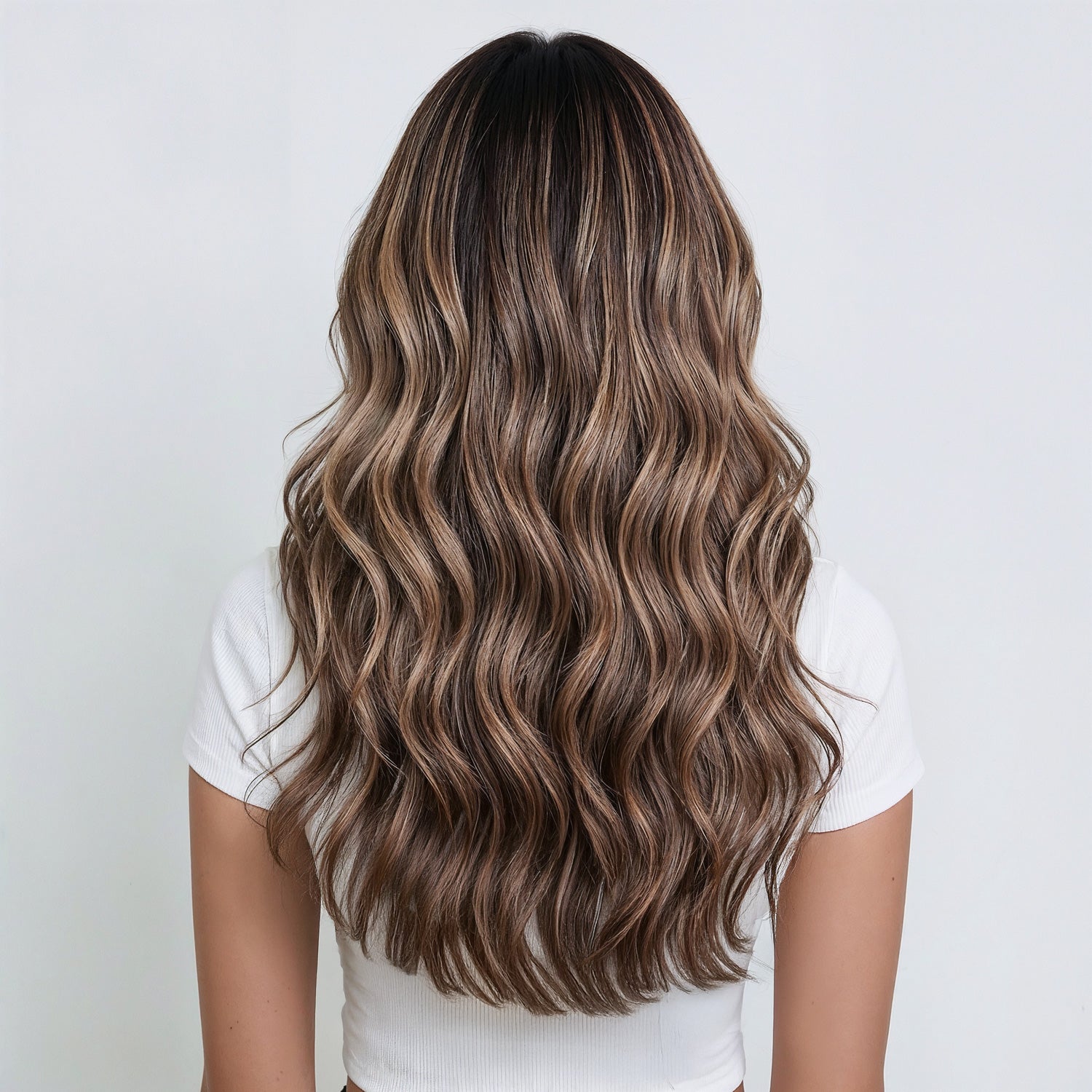 Backview of model with long hair extensions in a dark brown and dirty blonde mix