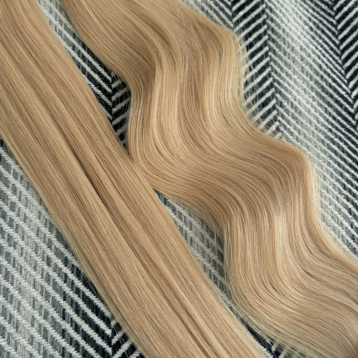 Sandy Blonde hair extensions on a patterned fabric background