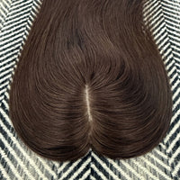 Brown hairpiece on a patterned fabric background