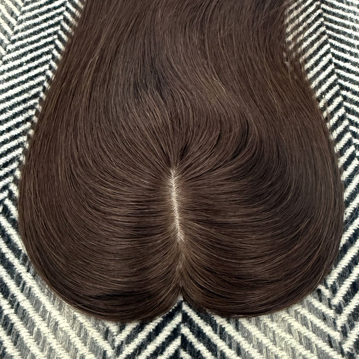 Brown hairpiece on a patterned fabric background