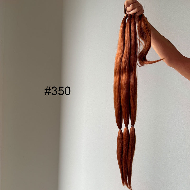 Copper hair extensions held by a hand against a neutral background with color code #350.