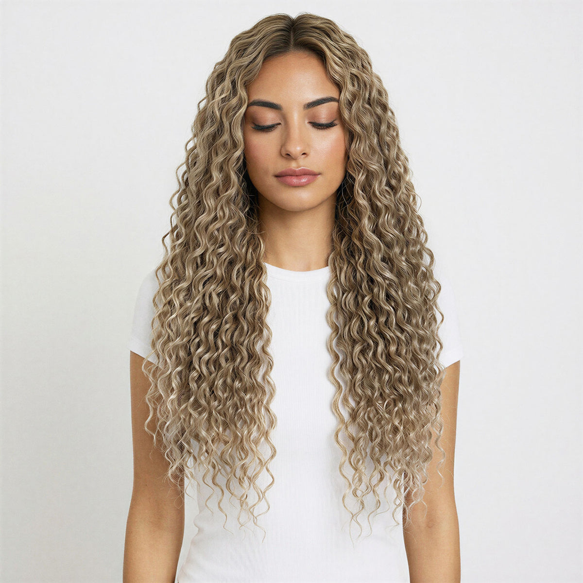 Woman with long, wavy beige blonde curly hair extensions against a white background