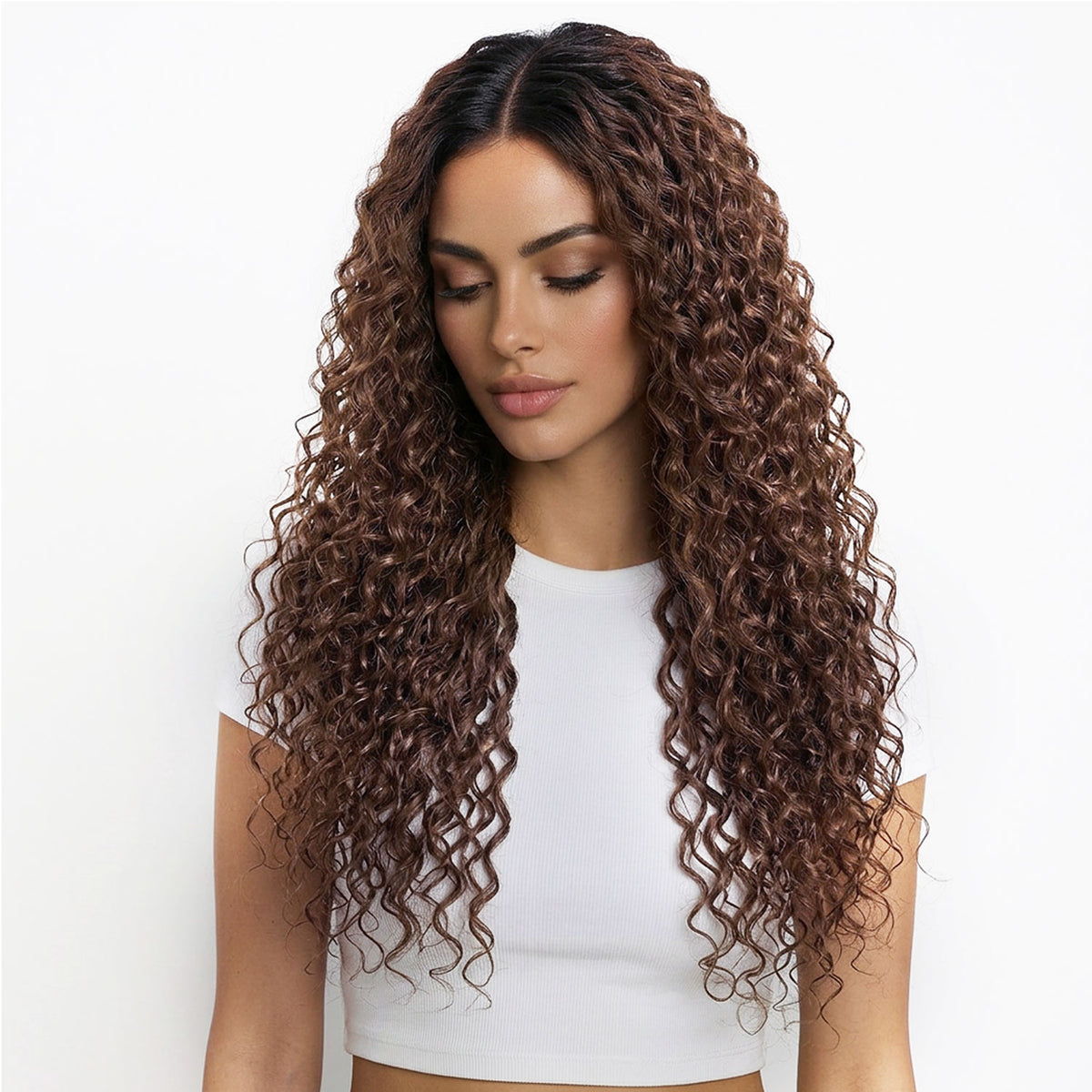 Woman with long, curly chestnut hair extensions wearing a white top on a white background