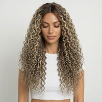Woman with long, wavy ash brown  and platinum blonde mix curly hair extensions wearing a white top on a light grey background