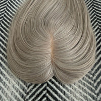 Light brown hair bun on a textured black and white background