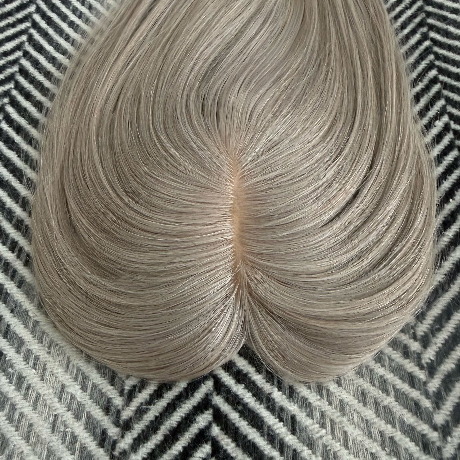 Light brown hair bun on a textured black and white background