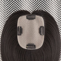 Hair extension with a gray base and black hair on a patterned background