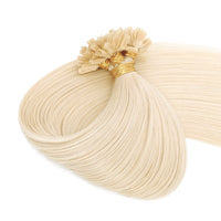 Blonde hair extensions with gold loops on a white background