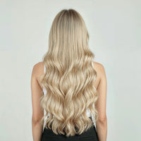 Person with long, ash blonde hair extensions on a plain background