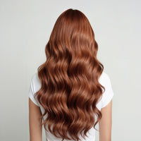 Person with long, wavy, copper brown hair on a plain background