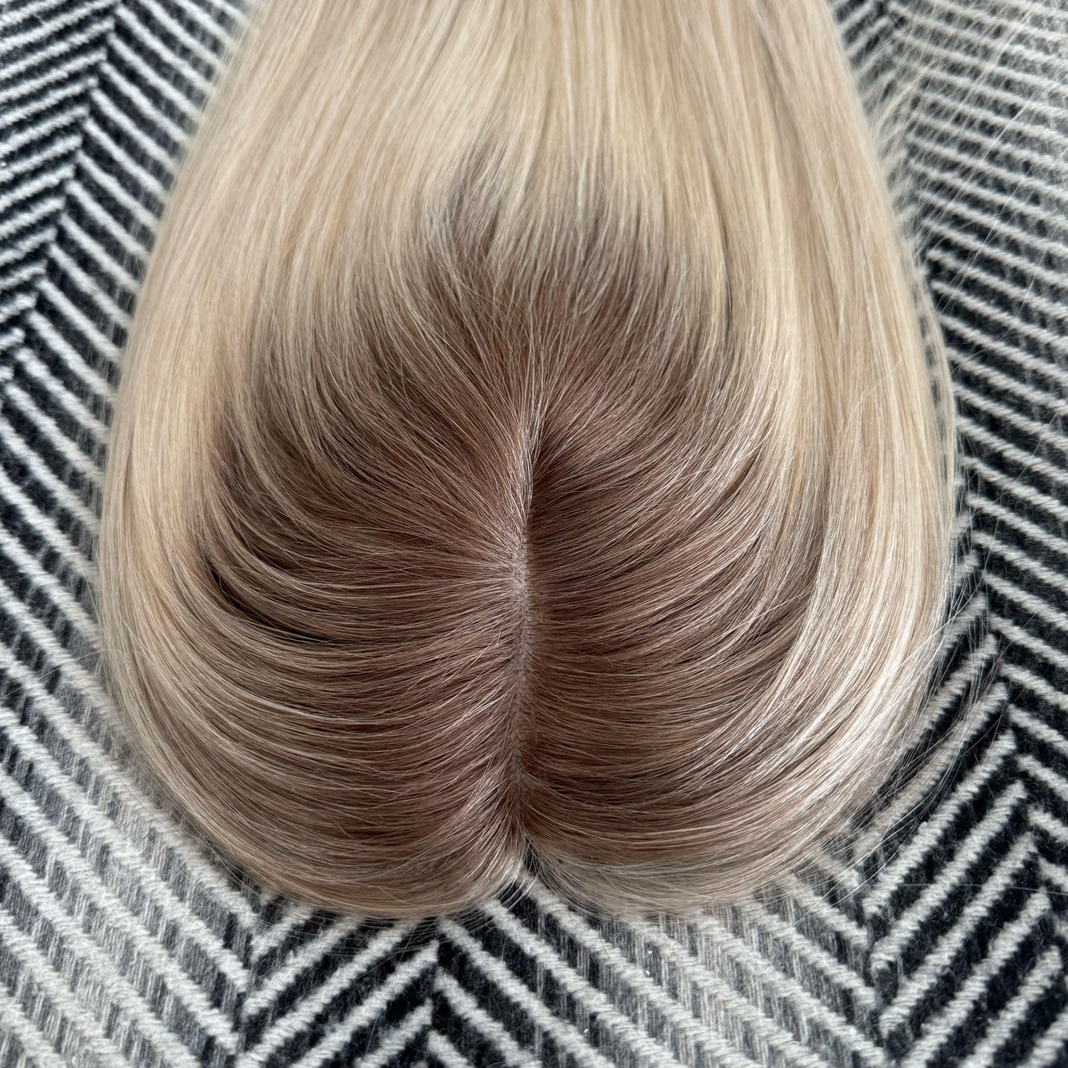 Blonde hair extension on a textured black and white background