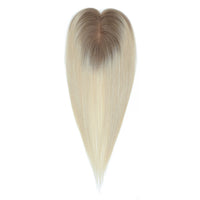 Blonde hair extension with gradient to brown on a white background