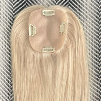 Blonde hair extension with clips on a textured background