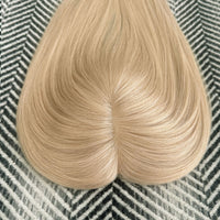 Blonde hair extension on a textured surface