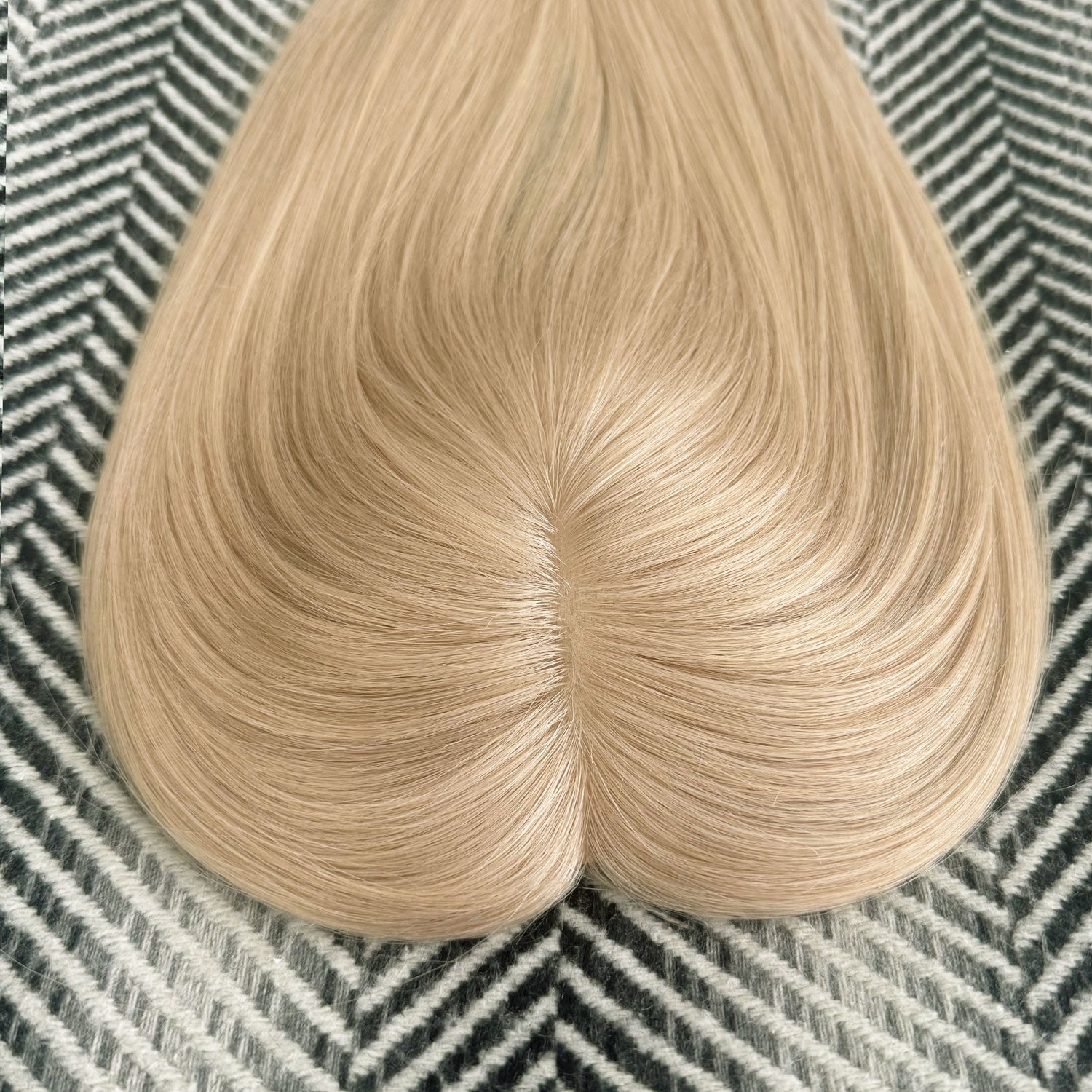 Blonde hair extension on a textured surface