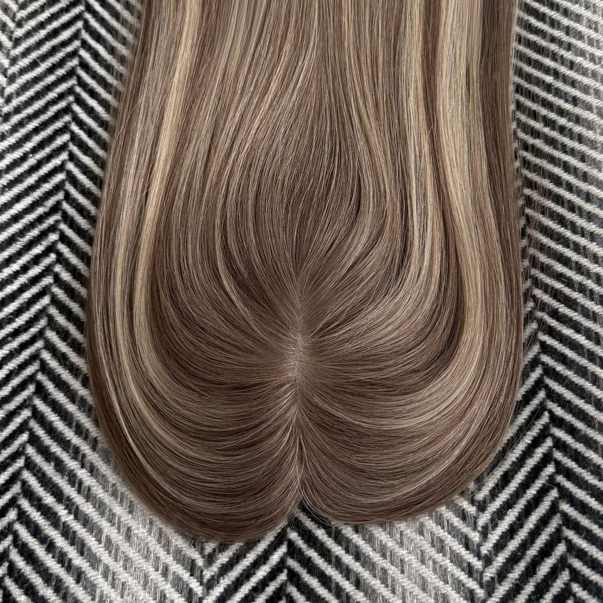 Brown hair extension on a patterned background