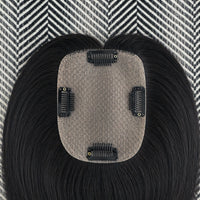 Black hair extension with a gray base on a patterned background