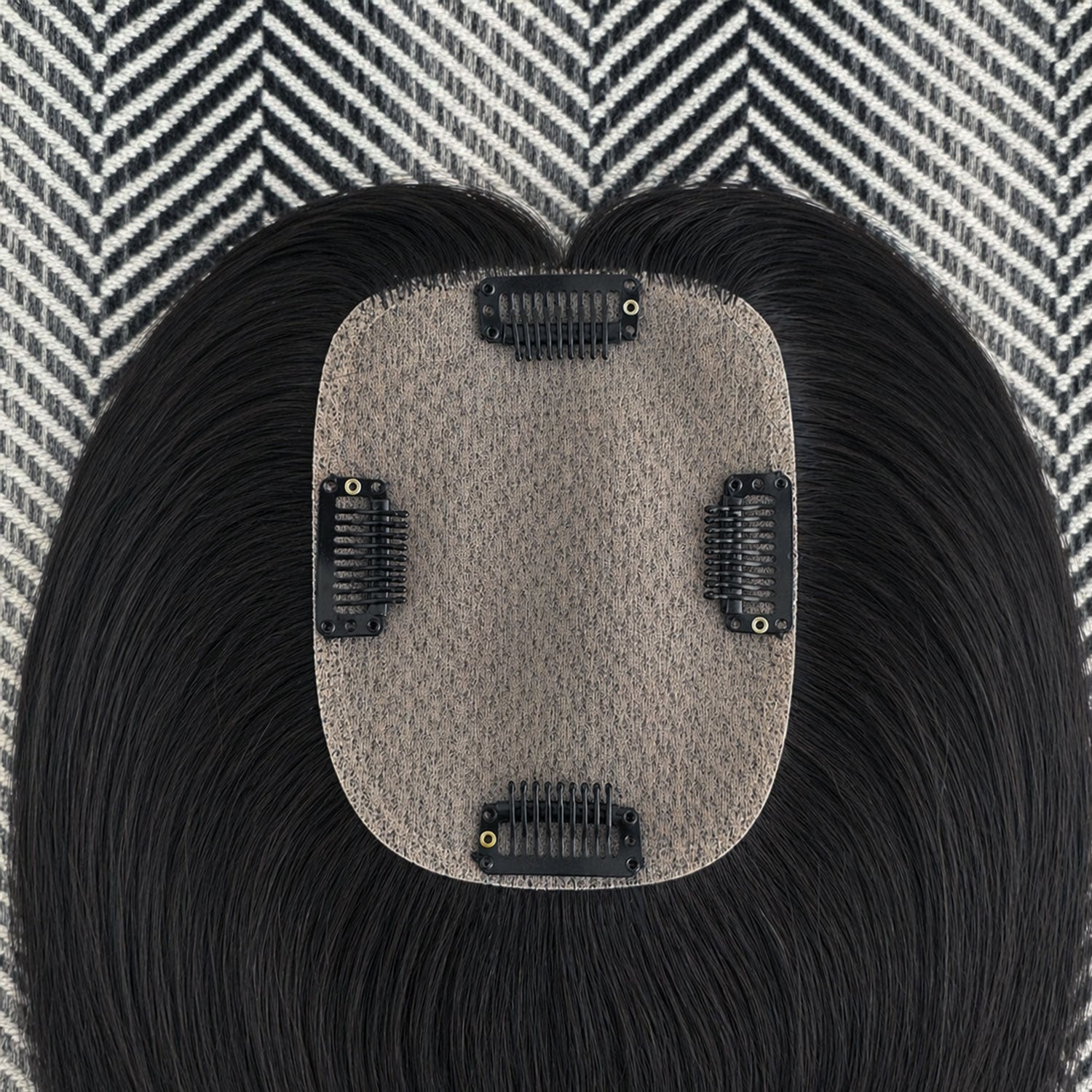 Black hair extension with a gray base on a patterned background