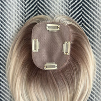 Blonde hair extension with clips on a textured background