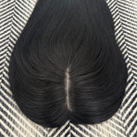 Black hairpiece on a patterned surface