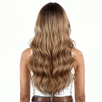 Person with long, wavy, blonde hair extensions on a white background