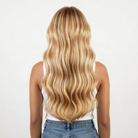 Person with long, wavy blonde hair on a plain background