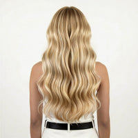 Person with long, wavy honey blonde hair on a white background